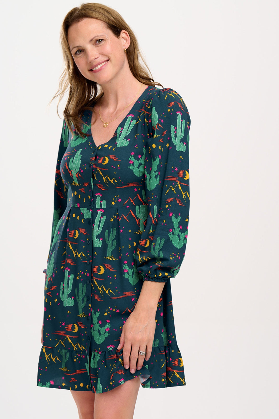Woman wearing a colorful cactus pattern dress on a white background
