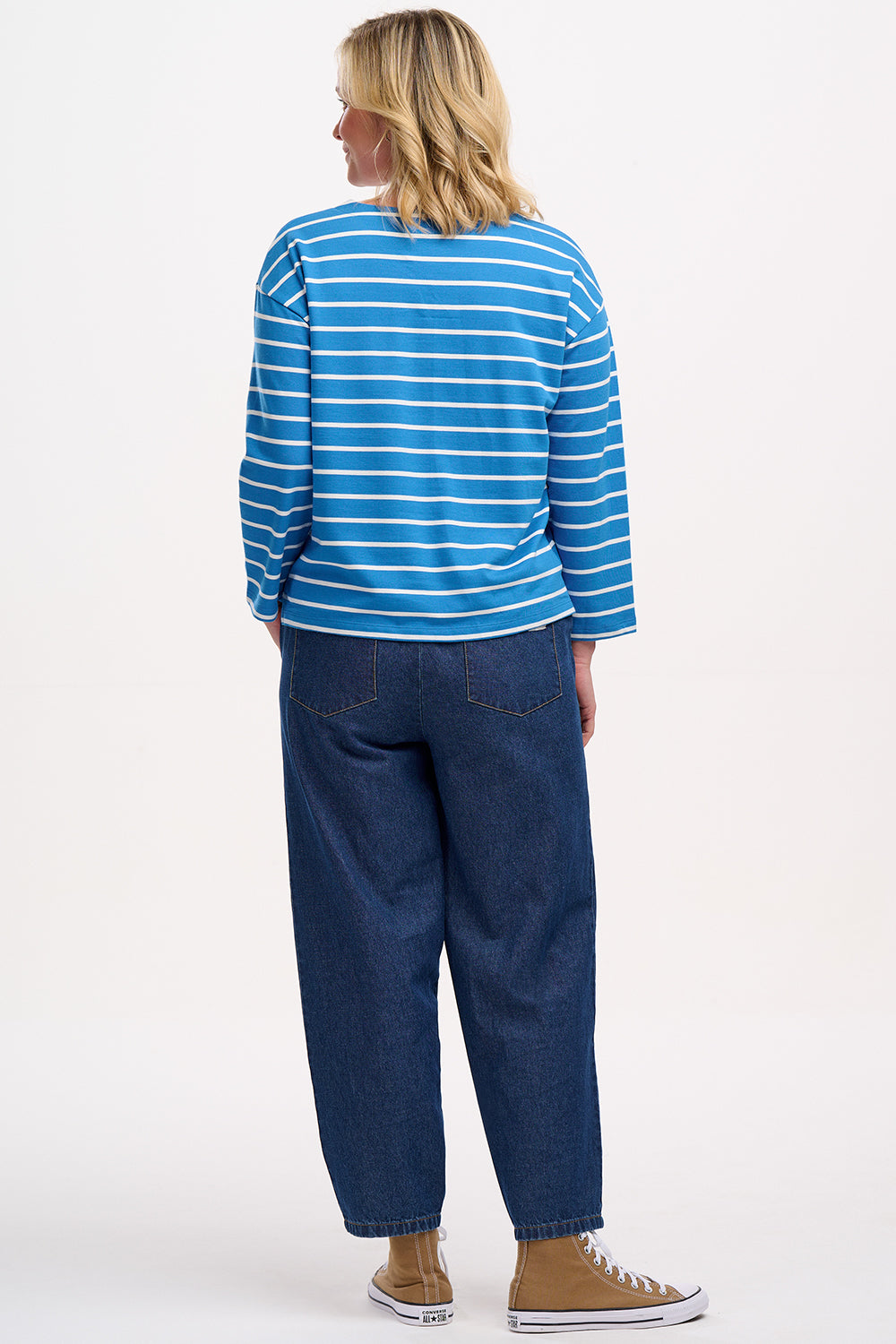 A woman wearing a French blue and lobster stripe Billie Breton top with embroidered lobster on the chest, paired with jeans