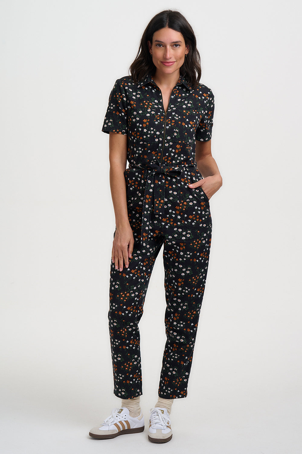 Woman wearing a black floral jumpsuit on a white background
