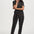 Woman wearing a black floral jumpsuit on a white background