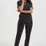 Woman wearing a black floral jumpsuit on a white background