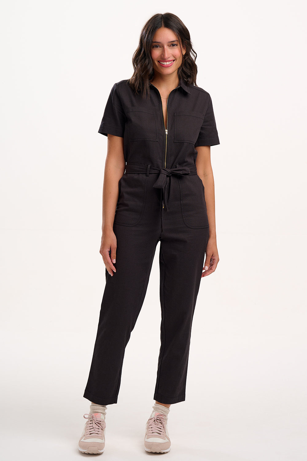 Woman wearing a black jumpsuit on a white background