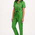 A model wearing a green boilersuit with rainbow flower embroidery on the chest pocket, featuring a half sleeve shirt upper, straight legs, and an exposed front zip.