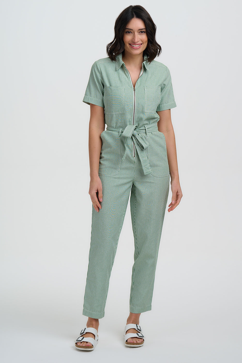 Woman wearing a light green jumpsuit on a white background