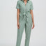 Woman wearing a light green jumpsuit on a white background