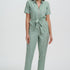 Woman wearing a light green jumpsuit on a white background