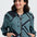 Woman wearing a black and teal patterned jacket on a white background