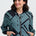 Woman wearing a black and teal patterned jacket on a white background
