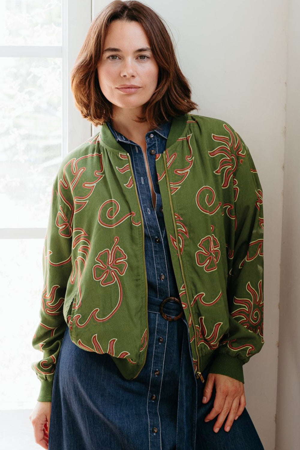 Woman wearing a green patterned jacket indoors