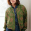 Woman wearing a green patterned jacket indoors