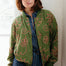Woman wearing a green patterned jacket indoors