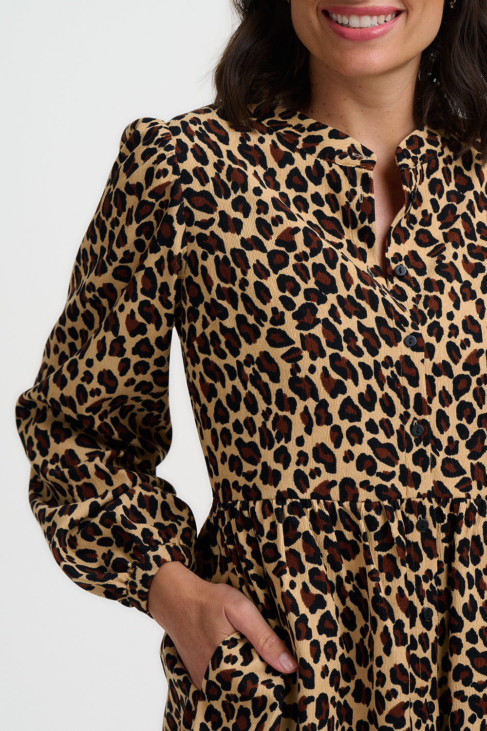 Person wearing a leopard print dress with a plain background