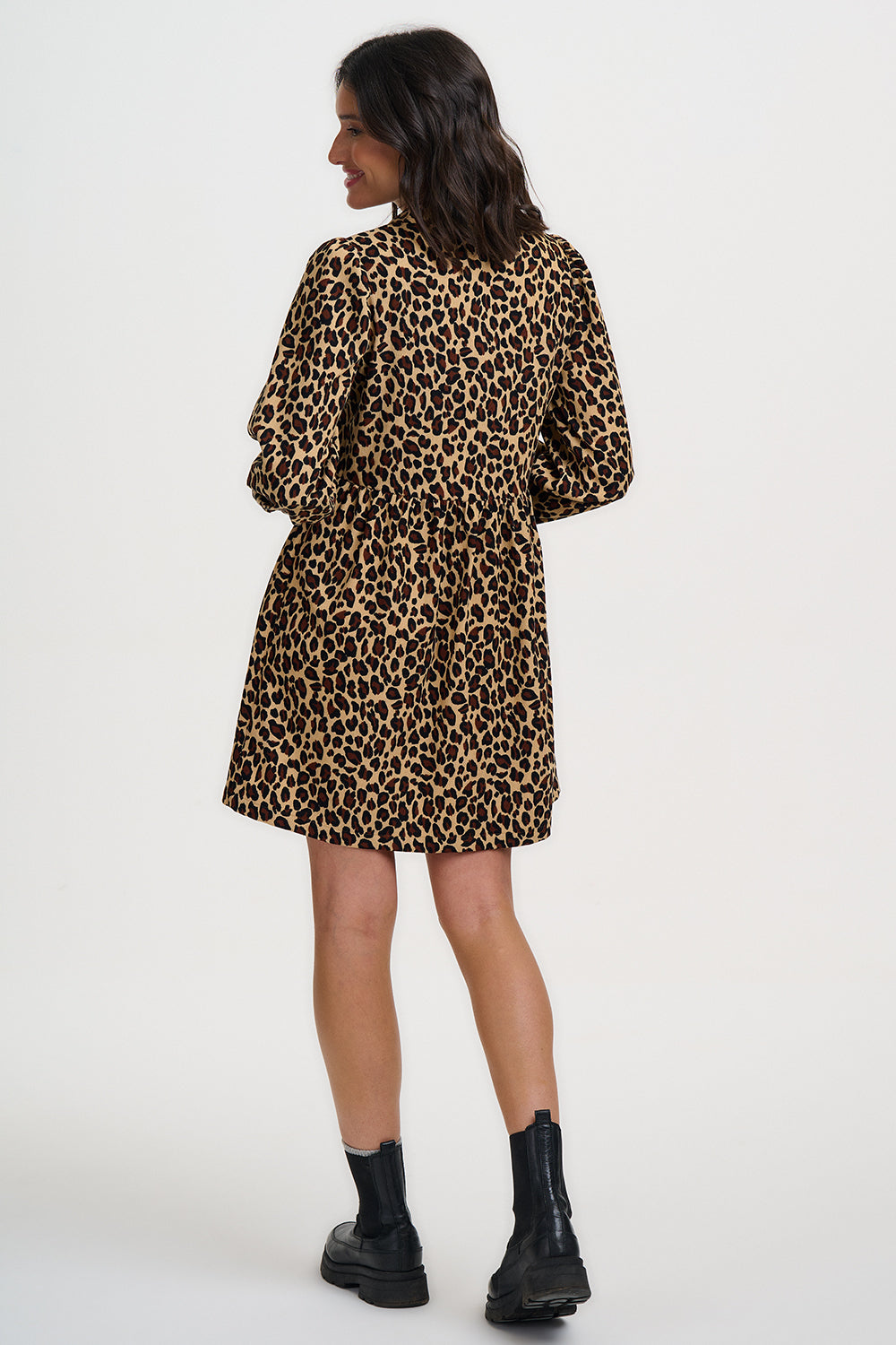 Woman wearing a leopard print dress on a white background