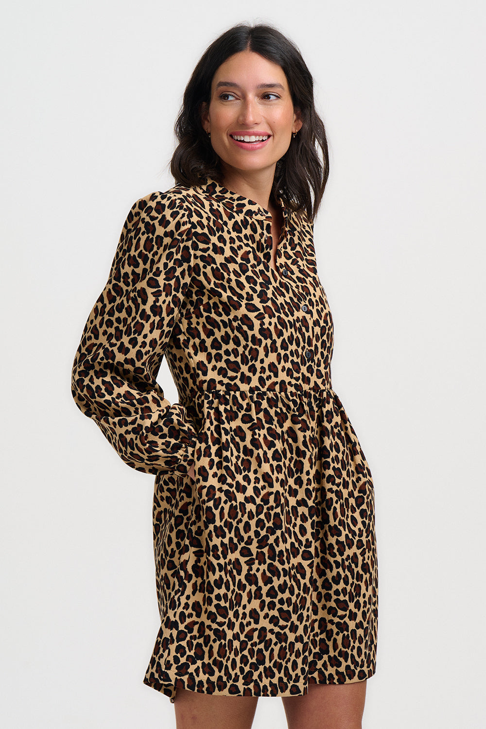 Woman wearing a leopard print dress on a white background