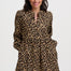 Woman wearing a leopard print dress on a white background