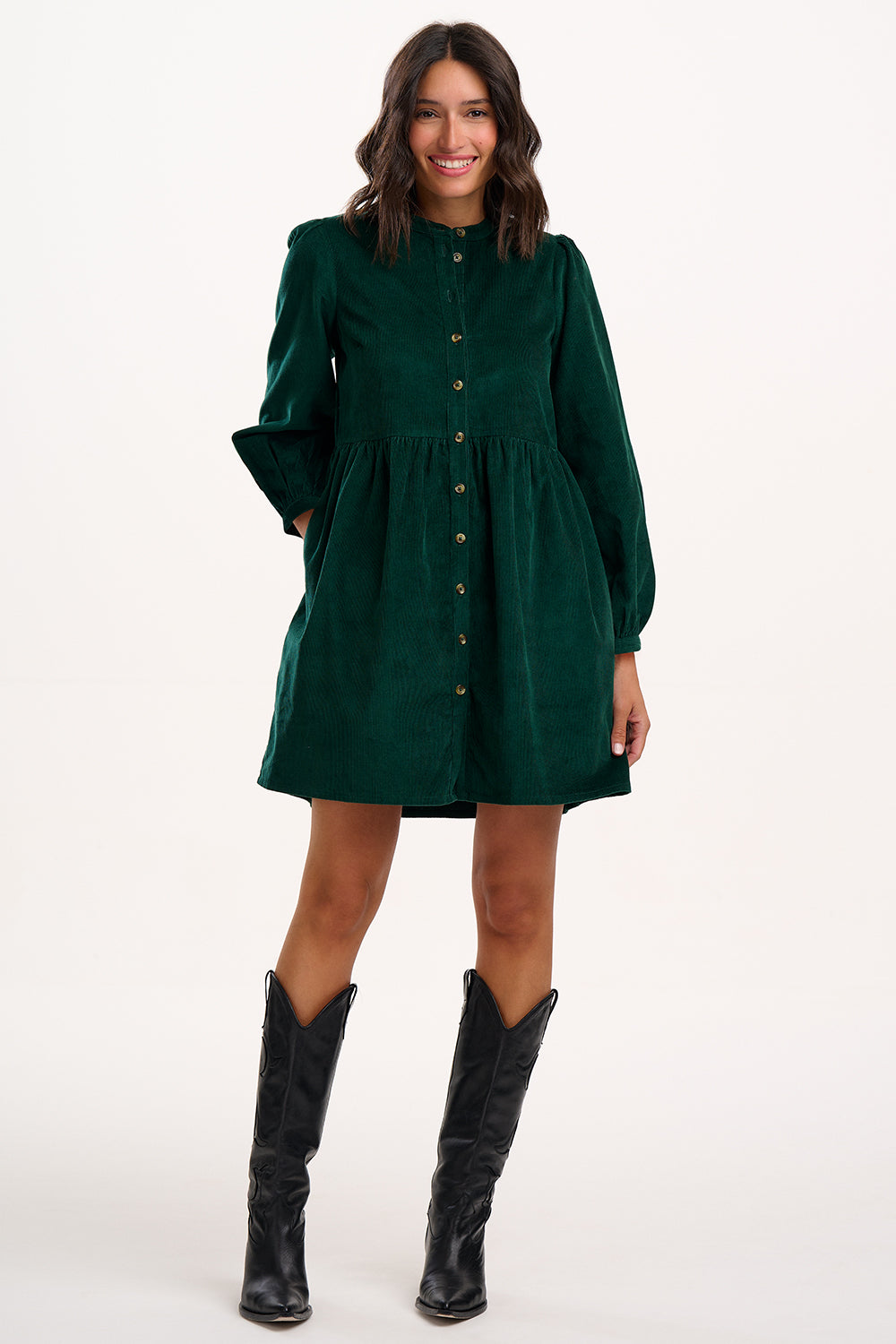 Model wearing green dress with long sleeves and buttons on a white background