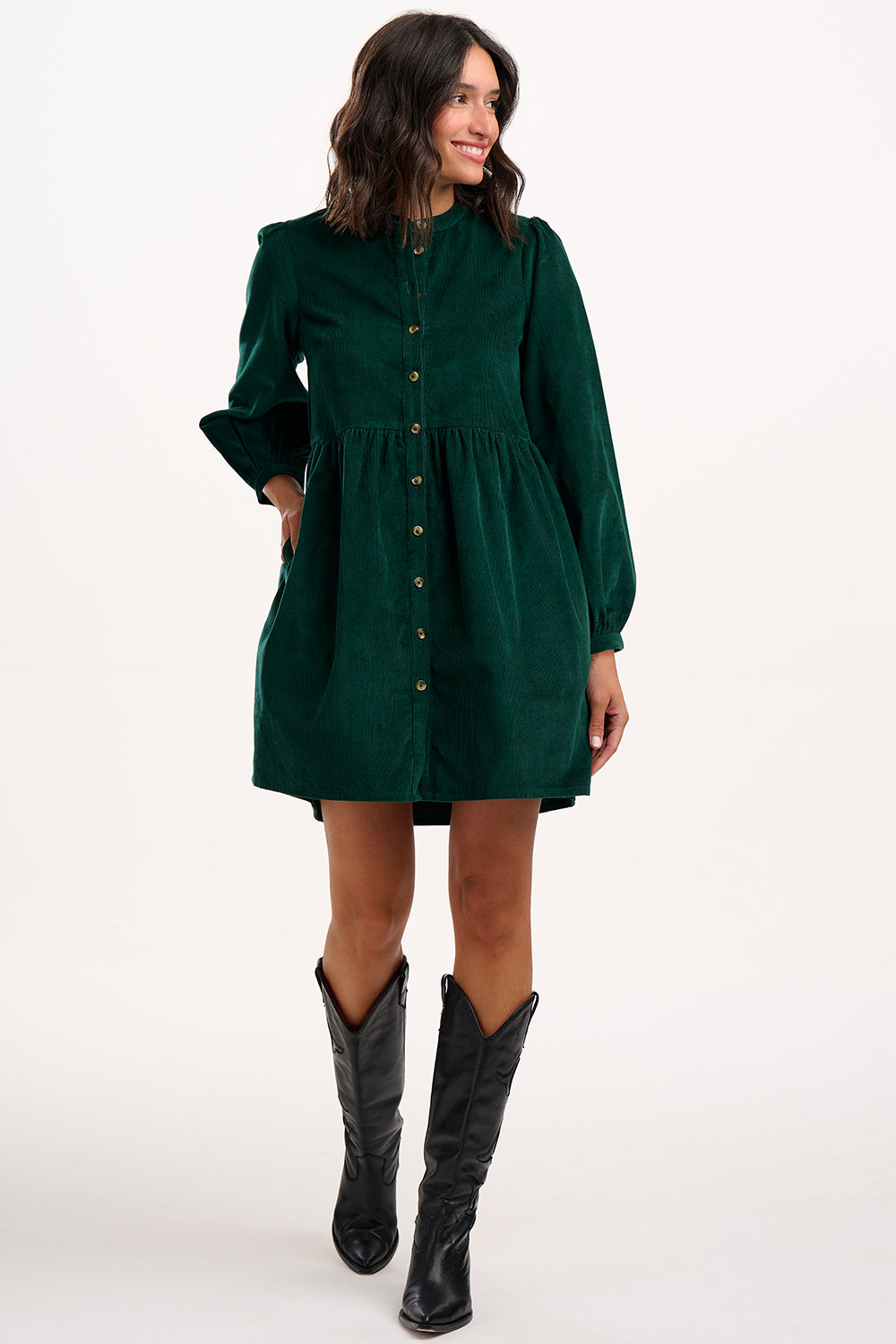Model wearing green dress with long sleeves and buttons on a white background