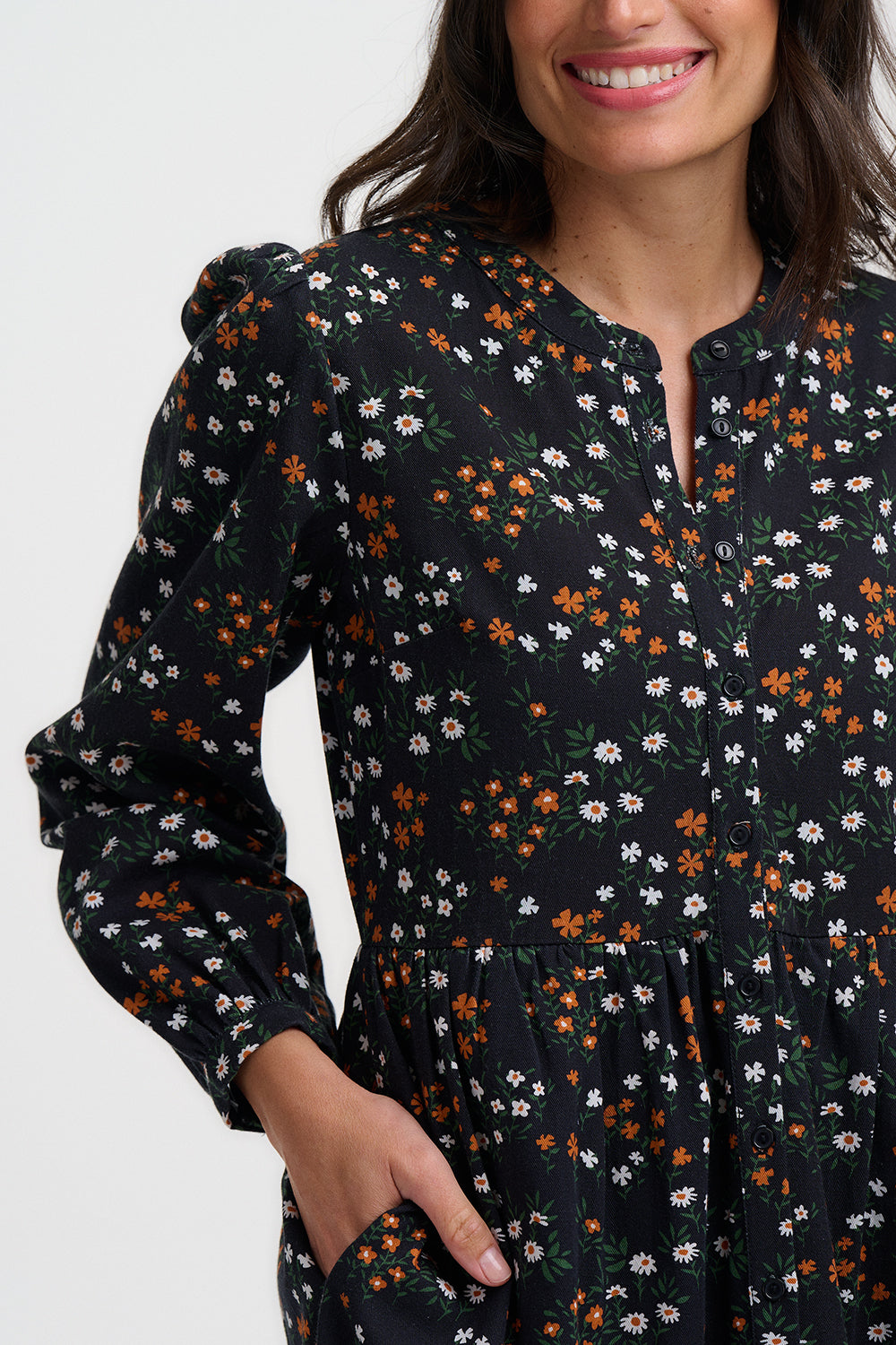 Woman wearing a black floral dress with a plain background