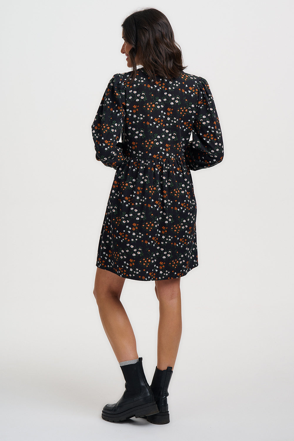 Woman wearing a black floral dress on a white background