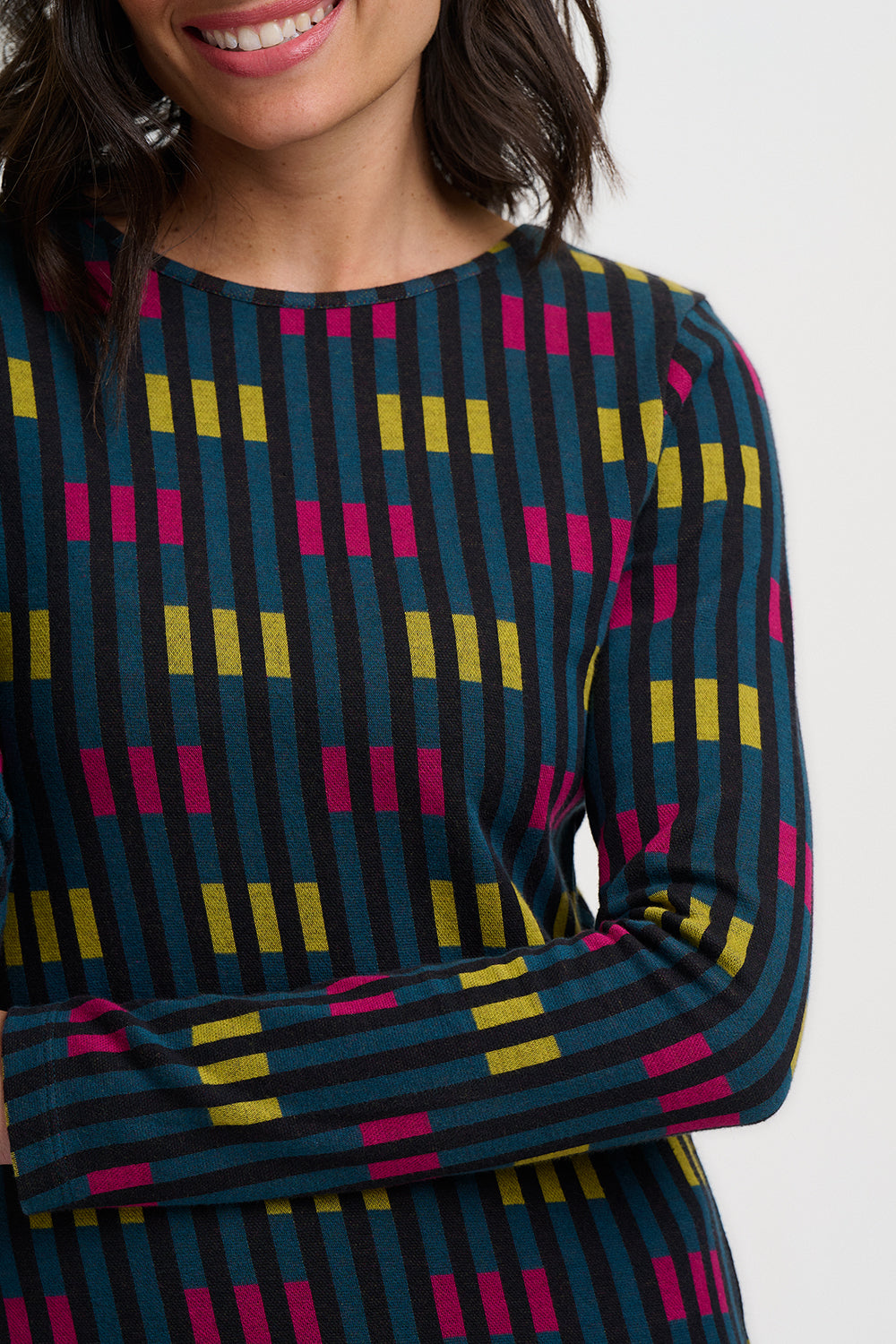 Person wearing a patterned dress with colorful geometric design on a white background