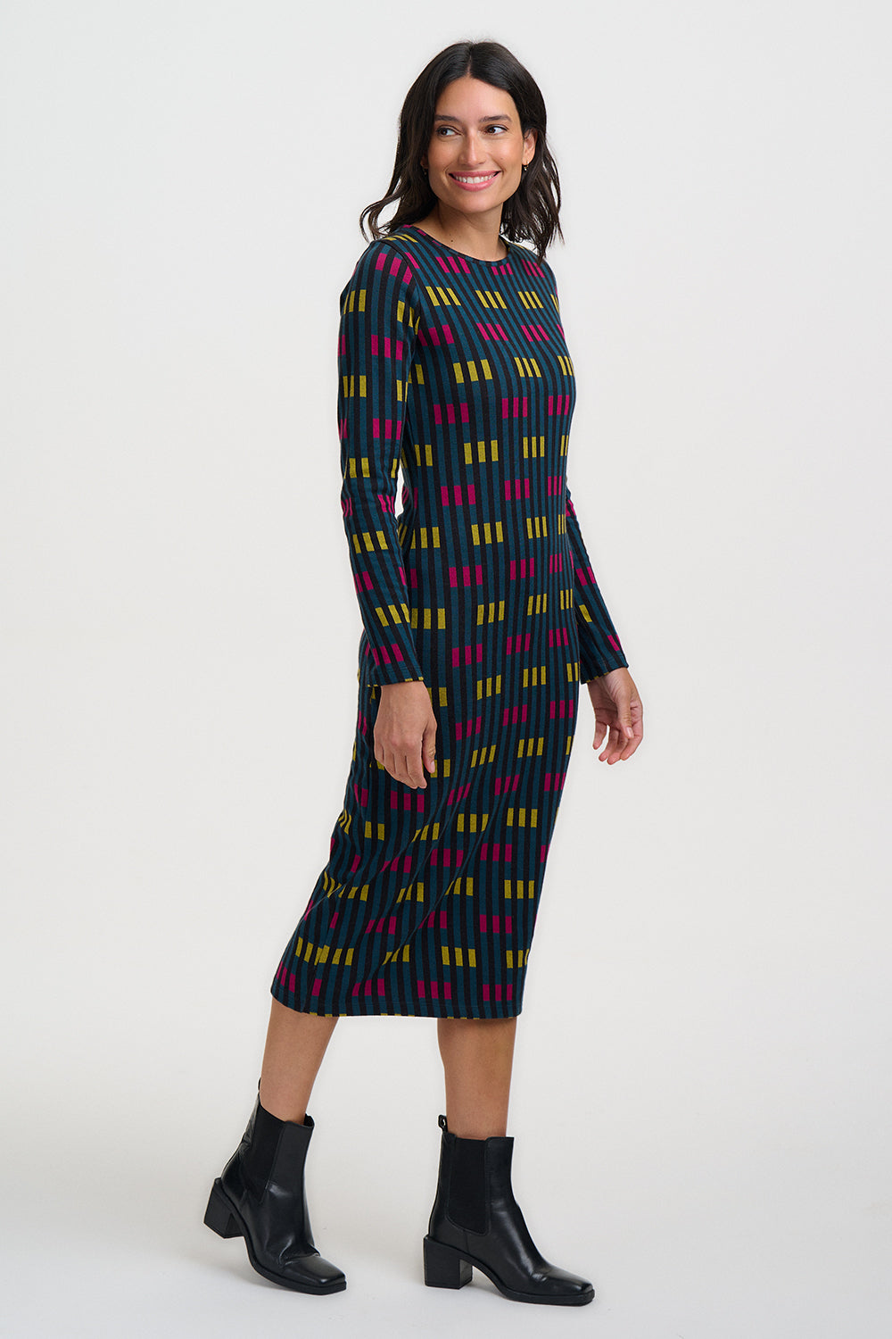 Woman wearing a patterned dress with long sleeves on a white background