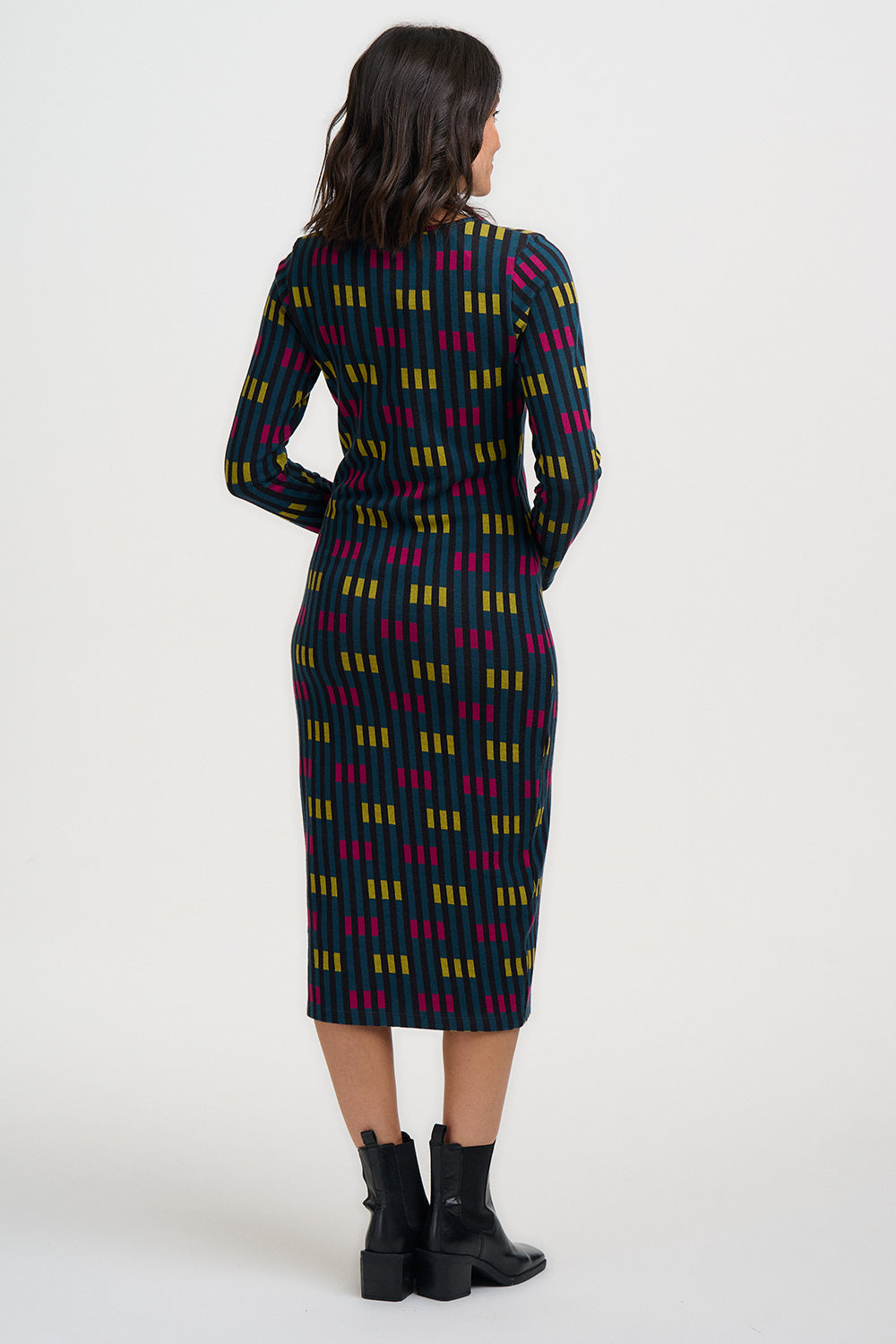 Woman wearing a patterned dress with long sleeves on a white background