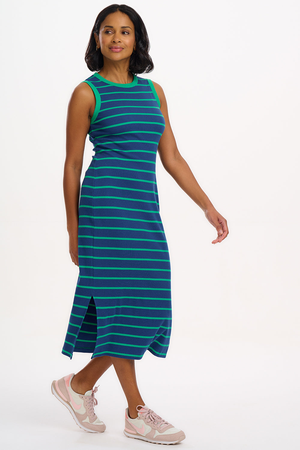 A model wearing a sleeveless, round neckline jersey dress with blue and green stripes.