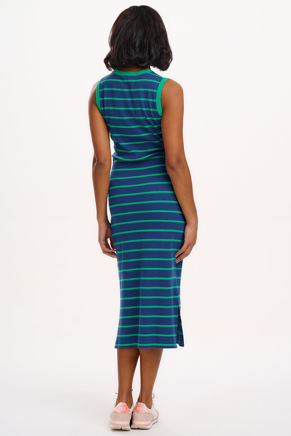 A model wearing a sleeveless, round neckline jersey dress with blue and green stripes.