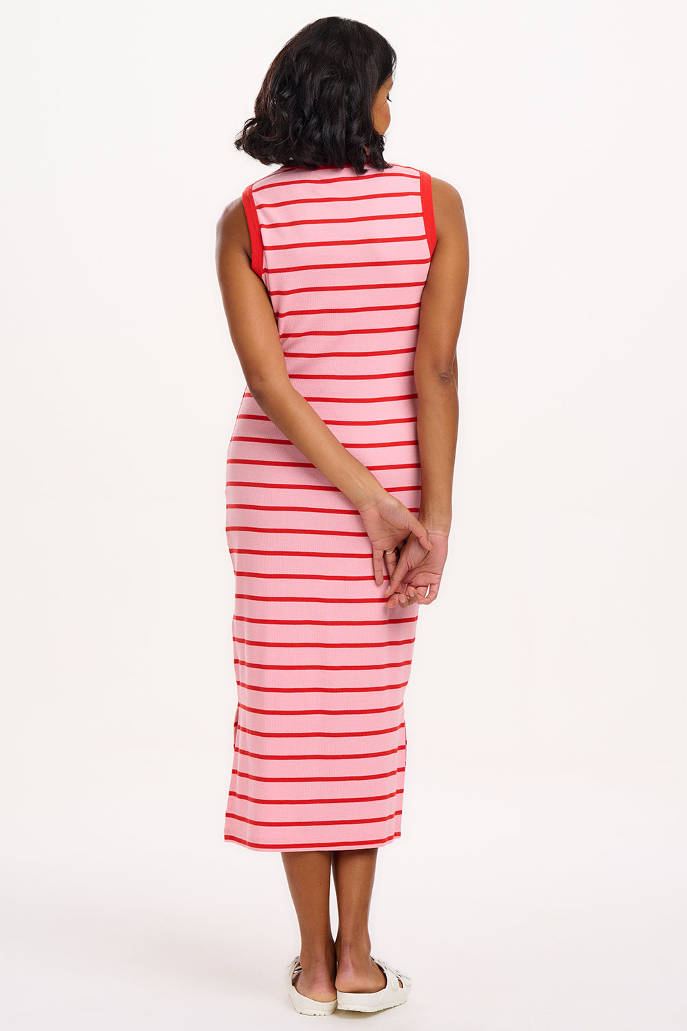 A model wearing a sleeveless, striped midi jersey dress in pink and red.