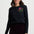Woman wearing a black long-sleeve shirt with a floral embroidery design on a white background