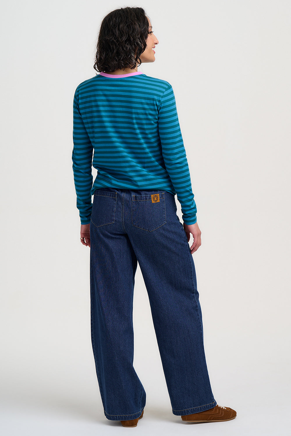 Person wearing a blue striped shirt and blue jeans on a white background