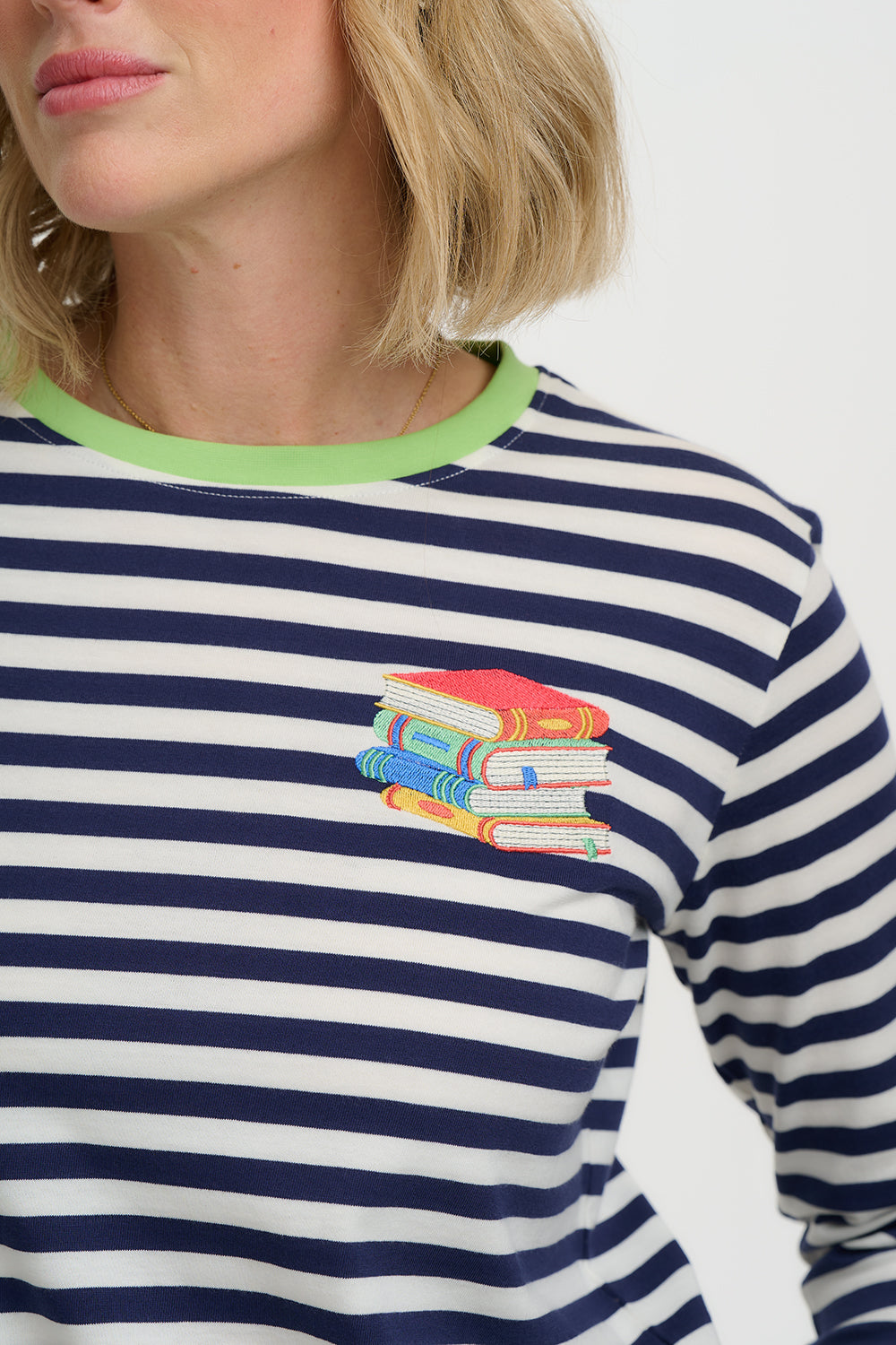 Navy and white striped shirt with colorful book design on a plain background