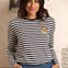 Woman wearing a striped sweater with a cat patch in a casual setting