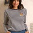 Woman wearing a striped sweater with a cat patch in a casual setting