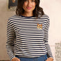Woman wearing a striped sweater with a cat patch in a casual setting