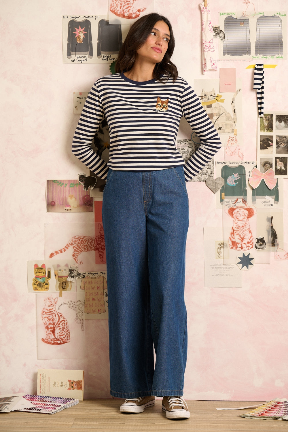Woman wearing a navy and white striped long-sleeve shirt with a small logo.
