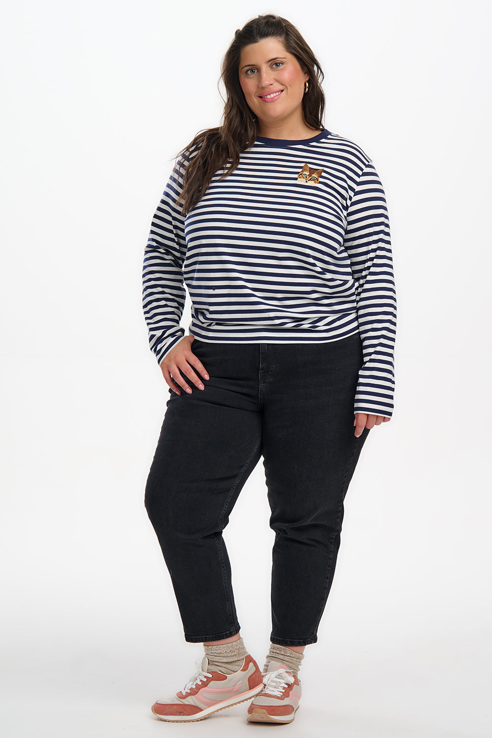 Person wearing a striped shirt and black pants on a white background