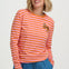 Woman wearing an orange and pink striped long-sleeve shirt with a small logo on a white background