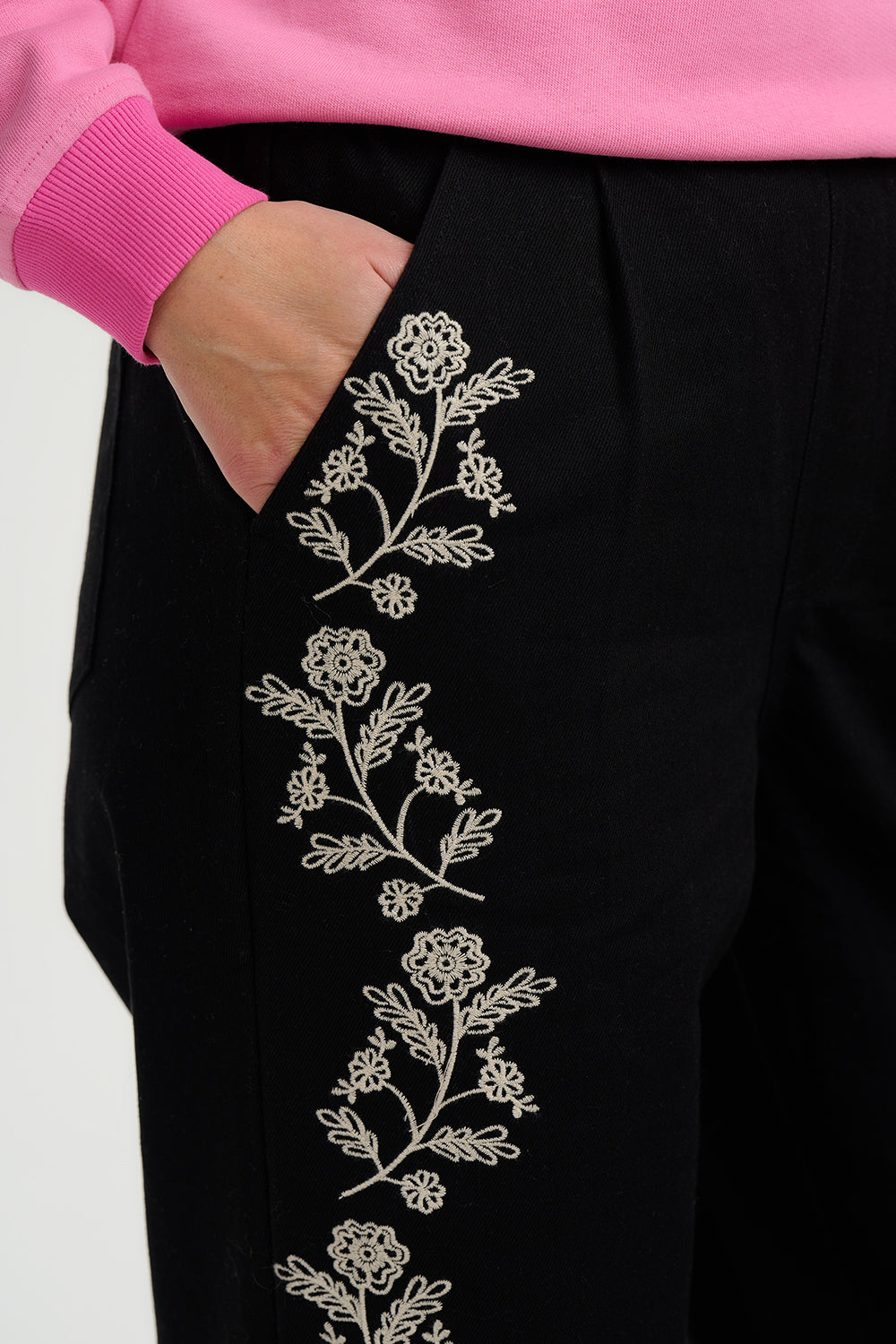 Black pants with floral embroidery on a white background