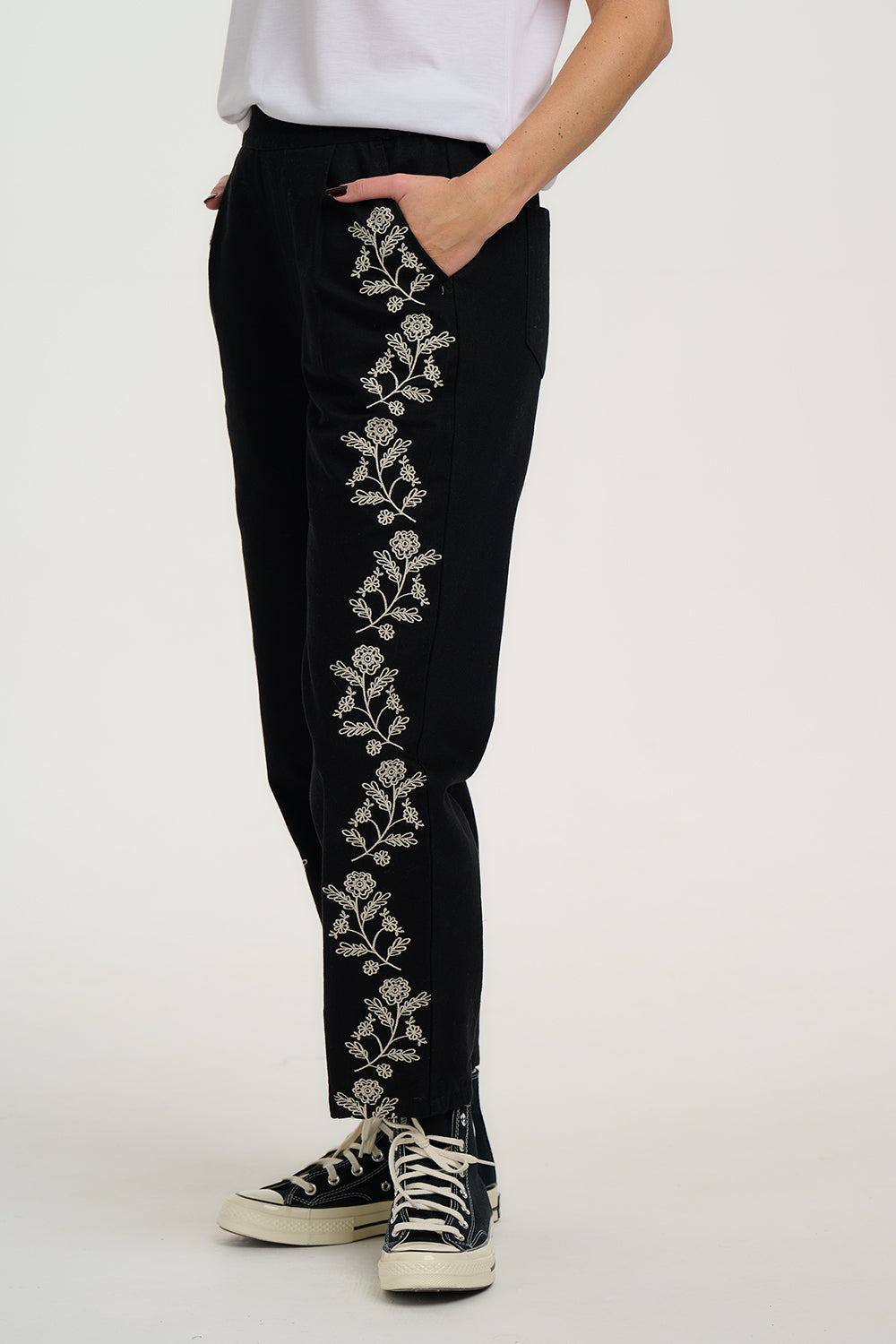 Black pants with floral embroidery on a white background