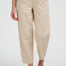 Person wearing beige pants and brown sandals on a white background
