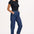 A model wearing the Calista Trousers in deep blue denim with a black top, showcasing the side and front pockets.