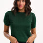 Woman wearing a green sweater against a white background