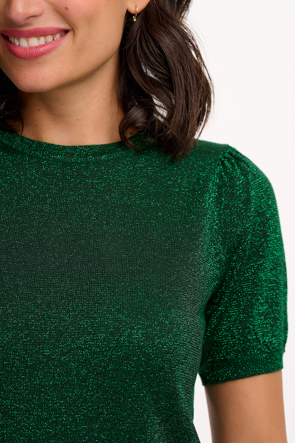 Close-up of a person wearing a green glittery dress with a blurred background