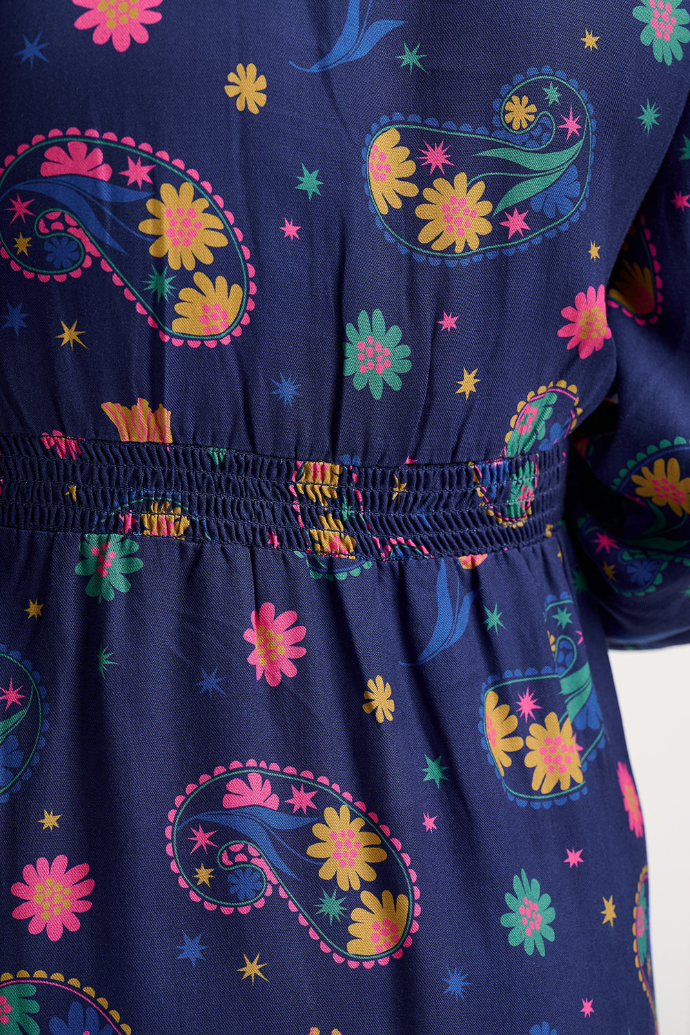 Navy blue dress with colorful floral and paisley patterns on a white background