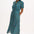 A model wearing a midi length shirt dress with a neat collar, puff short sleeves, and a green base with concentric circle pattern in blue, red, and pink.