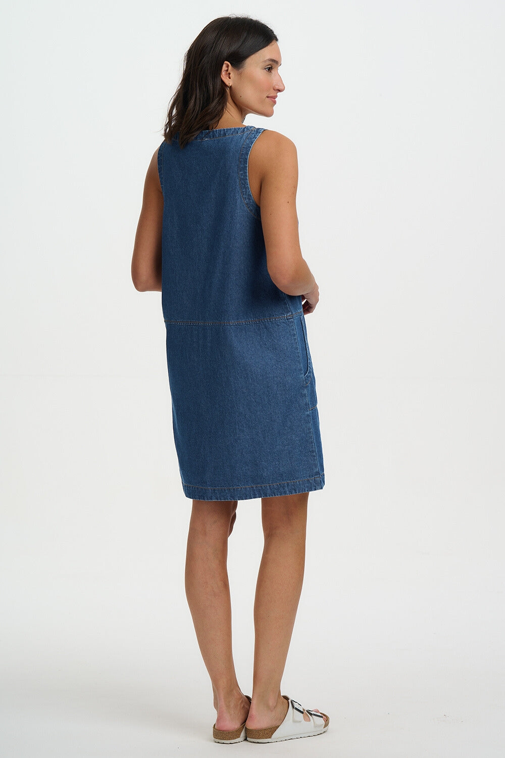 Woman wearing a blue denim dress on a white background