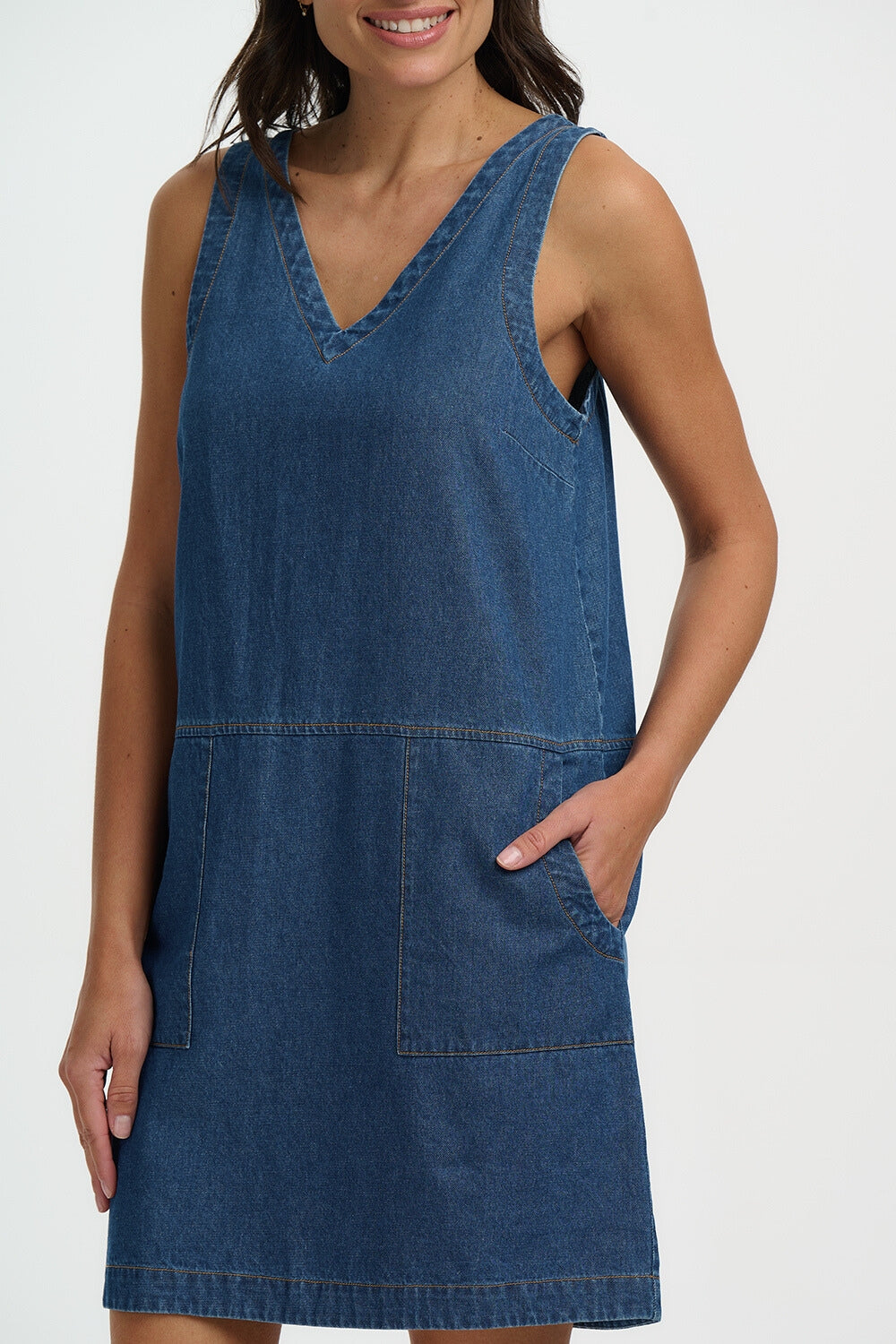 Woman wearing a blue denim dress on a white background