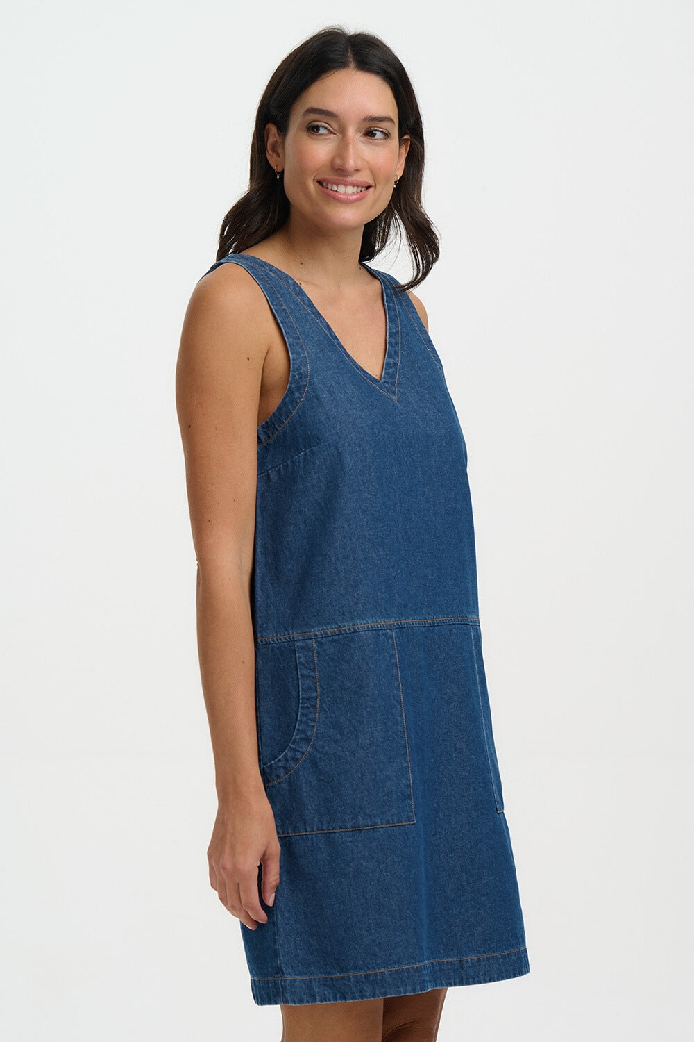 Woman wearing a blue denim dress on a white background