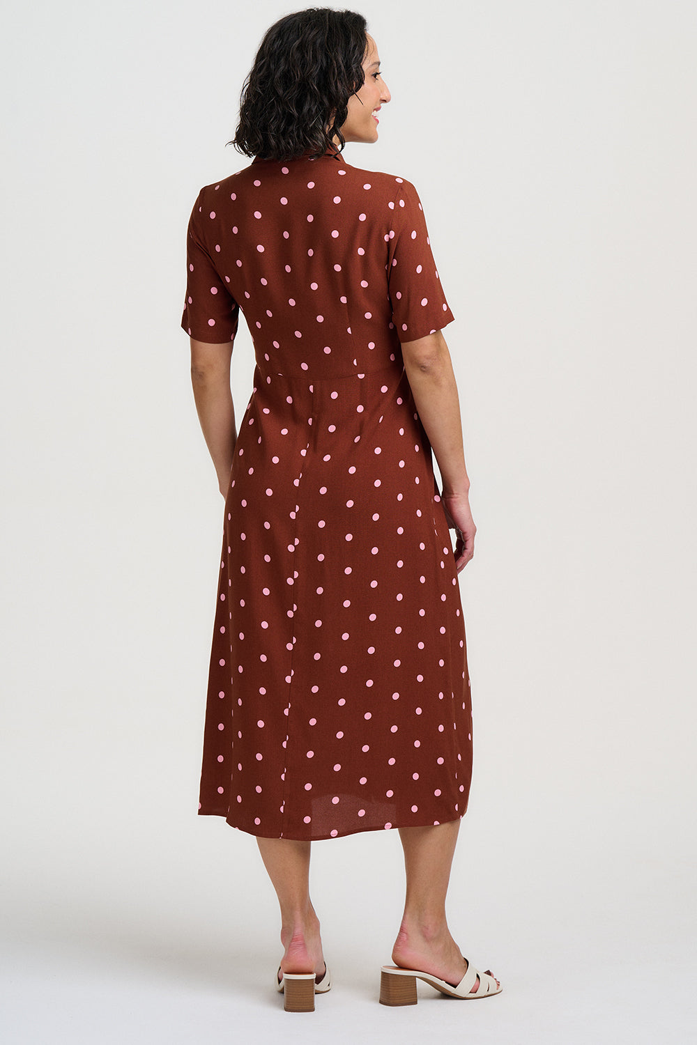 Brown dress with pink polka dots on a white background